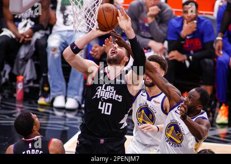 Los Angeles, United States. 15th Mar, 2023. Los Angeles Clippers center Ivica Zubac (L) is fouled by Golden State Warriors forward Draymond Green (R) during an NBA basketball game at Crypto.com Arena in Los Angeles. Credit: SOPA Images Limited/Alamy Live News Stock Photo