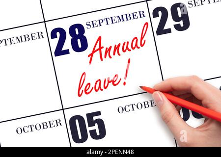 28th day of September. Hand writing the text ANNUAL LEAVE and drawing the sun on the calendar date September  28. Save the date. Time for the holidays Stock Photo