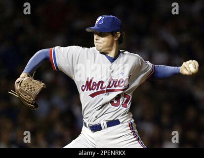 Montreal Expos starting pitcher Scott Downs, left, wipes his forehead as is  teammatesTony Batista, Maicer Izturis and Alex Gonzalez return to play  after the Atlanta Braves scores two runs during third inning