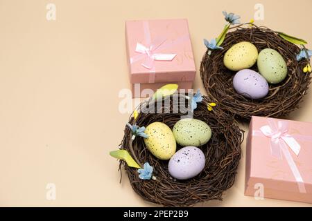 Gifts for Easter, Easter sale. Eggs in nests and gift boxes on a beige background. Stock Photo