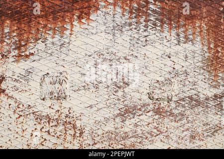 Corrugated rhombic rolled steel sheet with rust. White painted metal. Rusty metal texture background. Rust stains a lot. Stock Photo