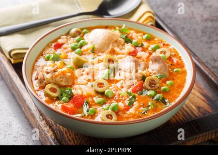 Puerto Rican dish asopao de pollo, a cross between soup and paella, is an easy, hearty one-dish meal featuring juicy chicken thighs, rice and seasonin Stock Photo