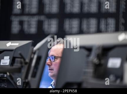 16 March 2023, Hesse, Frankfurt/Main: A stock trader on the stock exchange watches the price development on his monitor. Following the recent turbulence in the banking sector, financial experts are keeping a close eye on developments on the international stock markets. The Swiss central bank's aid for ailing Credit Suisse has acted as a calming pill for the German stock market. Photo: Boris Roessler/dpa Stock Photo