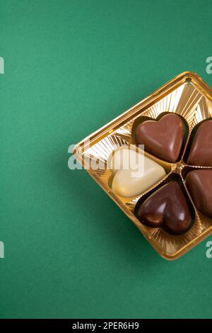 Close-up photo of chocolate hearts on a green background Stock Photo