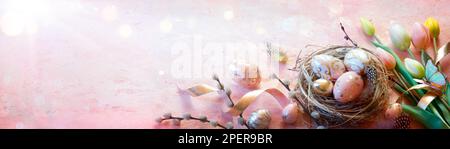 Easter - Eggs In Nest On Pink Table With Golden Decoration And Tulips Stock Photo