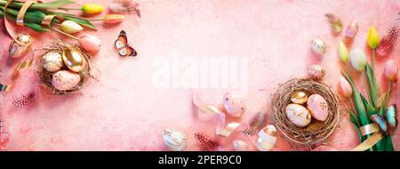 Easter Golden Eggs On Pink Background With Tulips And Nest Stock Photo