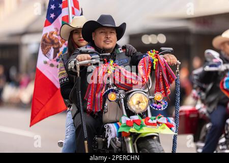 Brownsville, Texas, USA - February 26, 2022: Charro Days Grand International Parade, Men riding motorcycles carrying the national flag Stock Photo