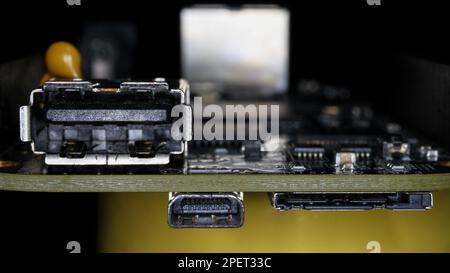An up-close shot of an aged computer motherboard with an array of wires connected to it Stock Photo