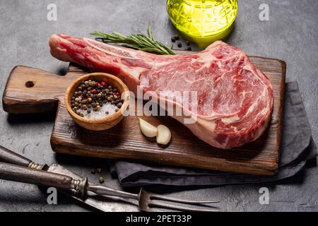 Raw Tomahawk beef steak and spices. Ready for grilling Stock Photo