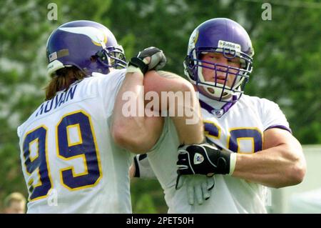 Former professional wrestler Brock Lesnar, left, signs a helmet