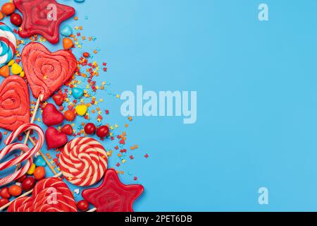Various candy sweets and lollipops on blue background and copy space for your text. Flat lay Stock Photo