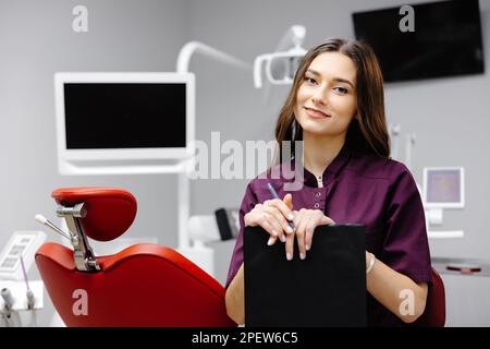 Doctor dentist working in office, using clipboard and making notes. Stock Photo