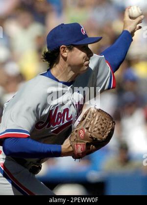 Montreal Expos starting pitcher Scott Downs, left, wipes his forehead as is  teammatesTony Batista, Maicer Izturis and Alex Gonzalez return to play  after the Atlanta Braves scores two runs during third inning