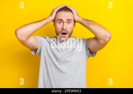 Photo of anxious embarrassed man wear grey clothes impressed bad news information isolated on yellow color background Stock Photo