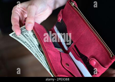 girl holds a wallet in her hands, shopping, dollars in her purse, wallet full of dollars Stock Photo