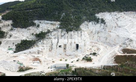 Heavy machines working at a huge marble quarry in Europe. Transporting the marble blocks. Stock Photo