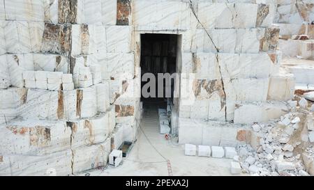 Heavy machines working at a huge marble quarry in Europe. Transporting the marble blocks. Stock Photo