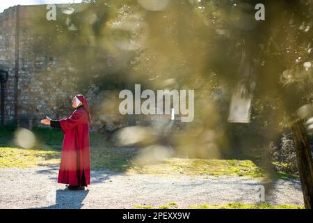 An actor dressed as Dante Aligheri recites The Divine Comedy in San Gimignano in Tuscany, Italy Stock Photo