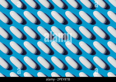 Pop Art Pattern Vitamin in White Pills Calcium Capsule Isolated On Blue Background, Biologically active additives concept Stock Photo