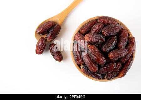 Date fruits in wooden bowl,on white background,top view Stock Photo