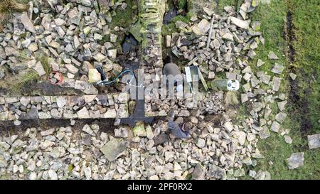 Drystone wallers rebuilding a wall as part of a government environmental project on a hill farm in the Yorkshire Dales, UK. Stock Photo