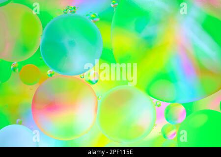 Multi colored abstract background with oil circles on water surface with a green background Stock Photo