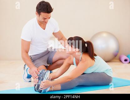 Giving great fitness advice. Young woman working out with the help of a personal trainer. Stock Photo