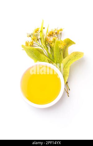 Isolated Honey bee in white bowl and linden glower on white background. Bee products. Healthy organic food concept. Top view Stock Photo