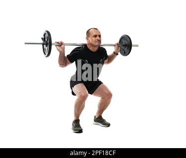 Athletic middle age man doing squats fitness workout with barbell, isolated on white background Stock Photo