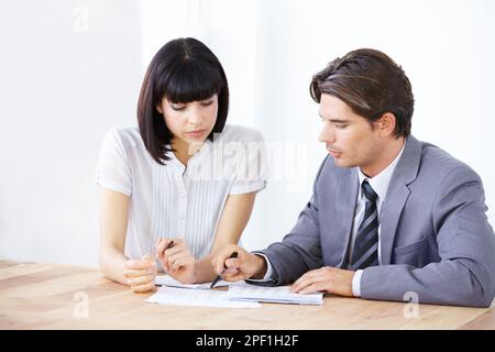 Planning first gets great results. Two young executives going over a project budget together. Stock Photo
