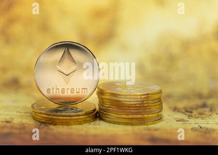 Business , Money, Technology and  cryptocurrency Concept. Closeup of gold Ethereum coin on stack of bitcoin coins on vintage world map. Stock Photo