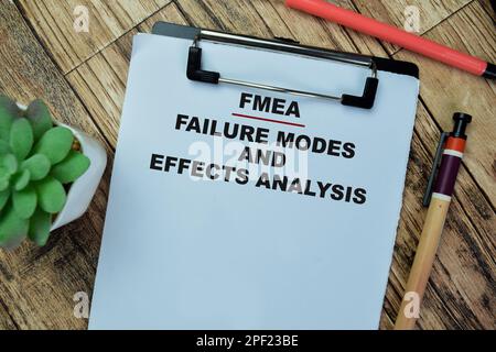 Concept of FMEA - Failure Modes and Effects Analysis write on paperwork isolated on Wooden Table. Stock Photo