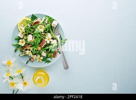 Spring salad with dandelion, asparagus, wild garlic, flowers, nettle and cheese. Healthy food for spring detox Stock Photo