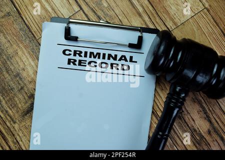 Concept of Criminal Record write on paperwork isolated on Wooden Table. Stock Photo