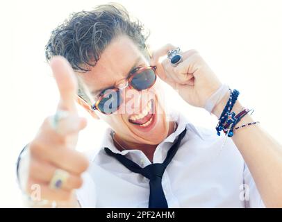 Youre the man. Low angle portrait of a handsome and stylish young man wearing sunglasses and pointing at the camera. Stock Photo