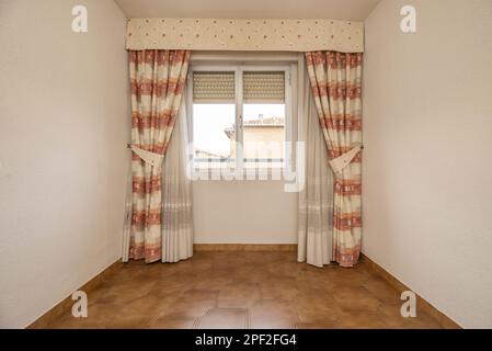 Empty room with aluminum and glass windows, dark stoneware floors and curtains with sheers Stock Photo