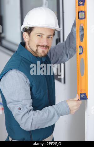 portrait of young tradesman using spirit level Stock Photo