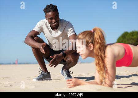 fit couple doing intense workout on the beach Stock Photo