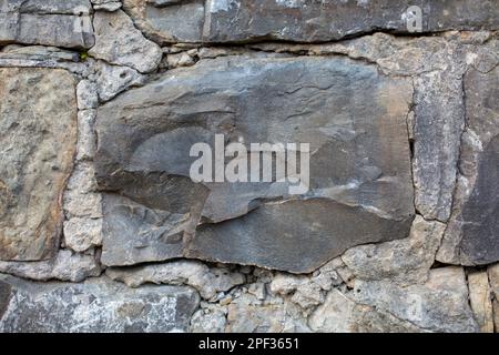 The large stone is securely embedded into the wall, adding strength and stability to the structure Stock Photo