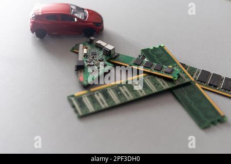 Toy cars on an electronic board with integrated circuits. The shortage of microchips and semiconductors creates a shortage of new cars. semiconductor Stock Photo