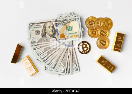 Bitcoins, gold bars, banknotes of 100 dollars on a white background top view, the concept of finance, business, wealth, success, cryptocurrency. Stock Photo