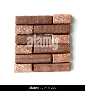 Craft sweets made of dark and milk chocolate with golden and silver decor on a white background top view. Stock Photo