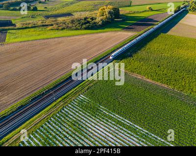 A modern InterCityExpress between fields in the countryside seen from a drone perspective Stock Photo