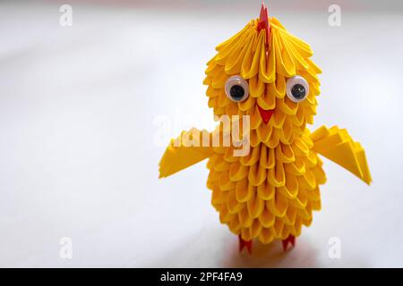 Handmade yellow origami Easter chick against white background, copy space. Stock Photo