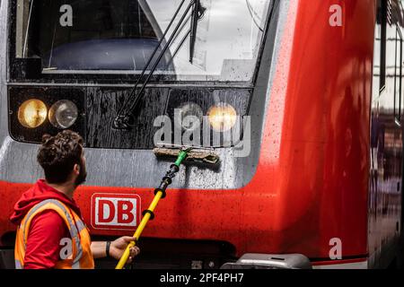 Service staff cleaning the windows of a train at the main station, Stuttgart, Baden-Wuerttemberg, Germany Stock Photo