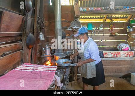 Muelle San Carlos, Costa Rica, A woman cooks over a wood-burning store in a rural farmhouse Stock Photo