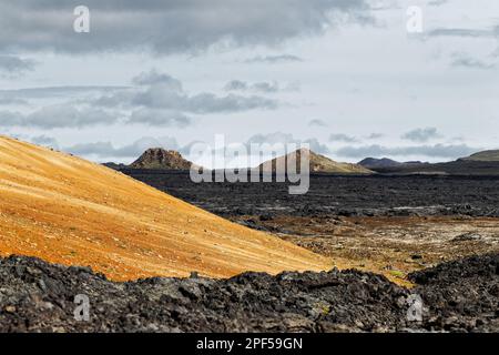 Wide view over a large cooled lava flow in Iceland, a huge volcanic eruption had deposited large amounts of rock material, on the left a mountain flan Stock Photo