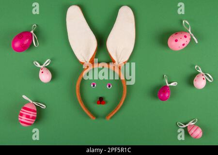 Funny easter green background with pink eggs and bunny face Stock Photo