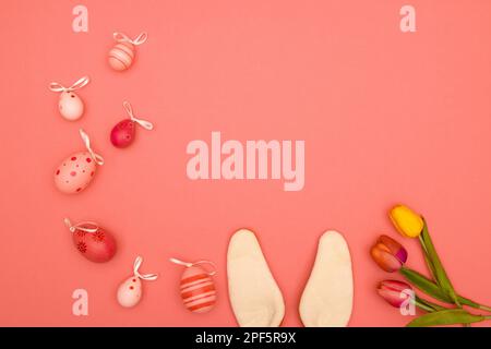 Easter background in pink, with space for copying, featuring bunny ears, tulips and Easter eggs Stock Photo