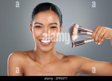 Make up your mind, if you cant then do your face. a beautiful young woman posing with a set of make-up brushes. Stock Photo